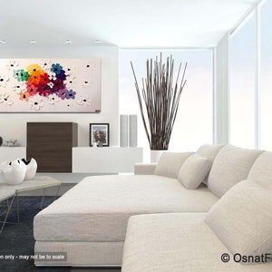 May include: Abstract painting of colorful flowers on a white background. The painting is displayed in a modern living room with a white couch and a coffee table.