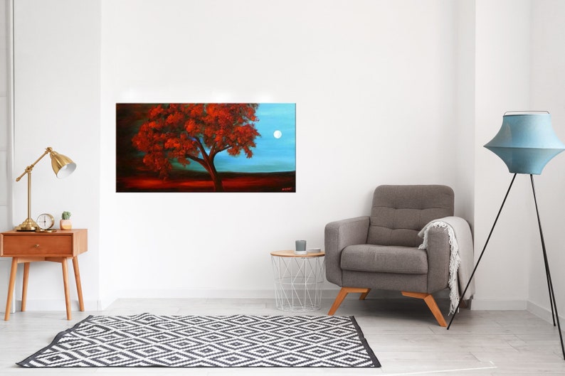 May include: A painting of a red tree with a full canopy against a blue sky with a white moon. The tree is in the foreground and the sky is in the background.