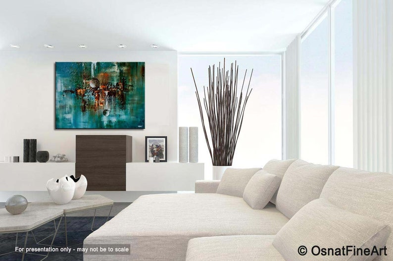 May include: Abstract painting with teal, brown, and white colors. The painting is hanging on a white wall in a modern living room with a white couch and a vase of brown branches.