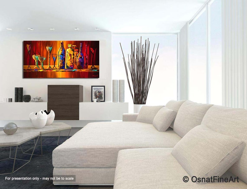 May include: Abstract painting of a still life with colorful bottles and glasses on a red background. The painting is framed and hanging on a white wall in a living room setting.