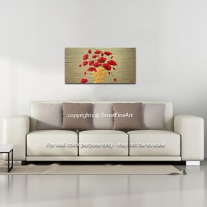May include: A painting of a bouquet of red poppies in a gold vase on a textured beige background. The painting is displayed on a white wall above a white sofa with beige pillows.