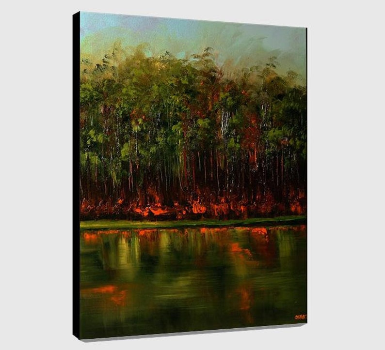 May include: A painting of a forest reflected in a still lake. The trees are mostly green with some red and orange hues. The water is a dark green with reflections of the trees.