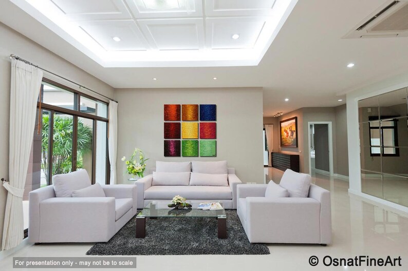 May include: A modern living room with white couches and a coffee table. A colorful abstract painting hangs on the wall above the couch.