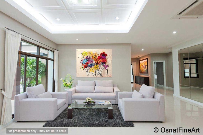 May include: A living room interior with white couches and a coffee table. A large abstract painting of colorful flowers hangs on the wall.