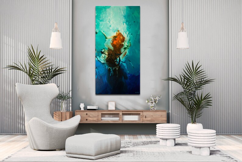 May include: Abstract painting with blue, green, and orange colors. The painting is hanging on a wall in a modern living room with a white armchair, a wooden coffee table, and two white plant stands with green plants.