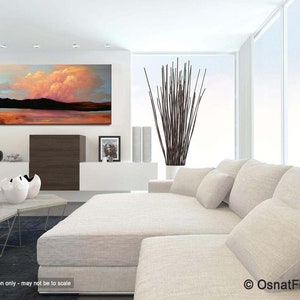 May include: Abstract landscape painting with a pink and orange sky, a dark mountain range, and a reflective body of water. The painting is displayed in a modern living room setting with a white couch and a plant.