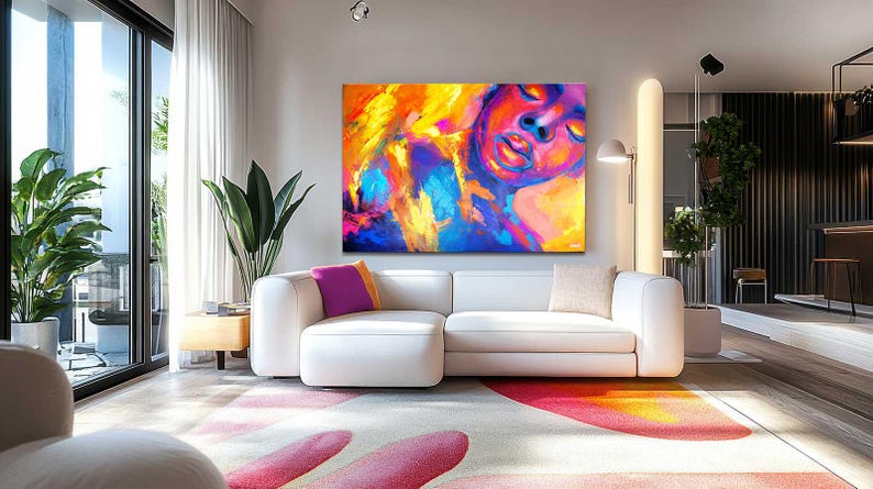 May include: A modern living room featuring a large abstract painting with vibrant colors of yellow, orange, blue, and purple. A white sectional sofa with colorful throw pillows sits below the artwork. The room has large windows and a patterned rug.