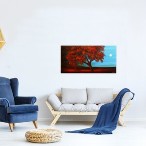 May include: A painting of a lone tree with red leaves against a blue sky with a full moon. The tree is in the foreground and the moon is in the background. The painting is framed and hanging on a white wall.