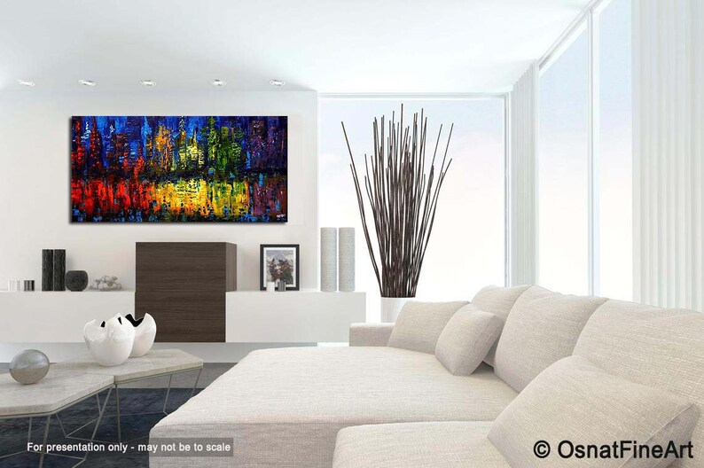 May include: Abstract painting of a cityscape in vibrant colors, including red, yellow, blue, and green. The painting is displayed on a white wall in a modern living room setting.