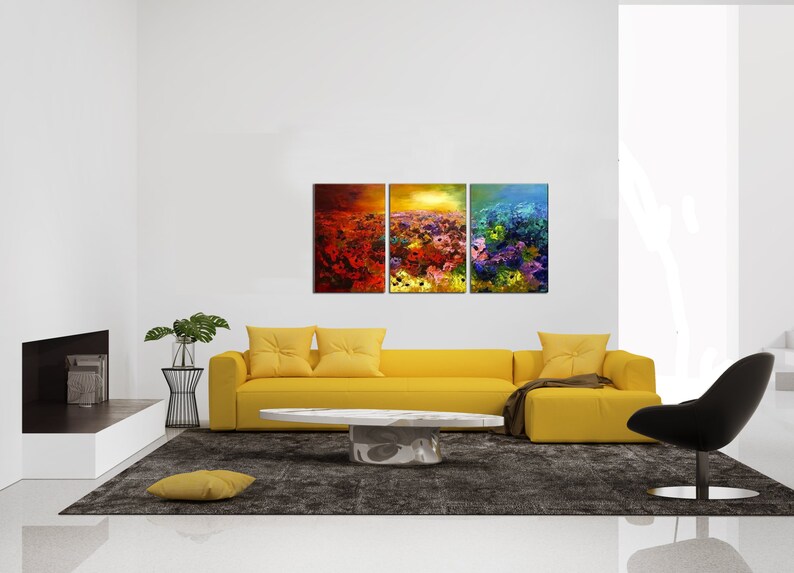May include: A three-piece abstract art print set featuring a field of colorful flowers. The prints are framed and hung on a white wall above a yellow sofa.