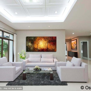 May include: A living room interior with a large abstract painting of a forest scene in shades of orange, yellow, and green. The painting is hanging on a wall above a white sofa. There are two white armchairs in front of the sofa and a glass coffee table in the center of the room.