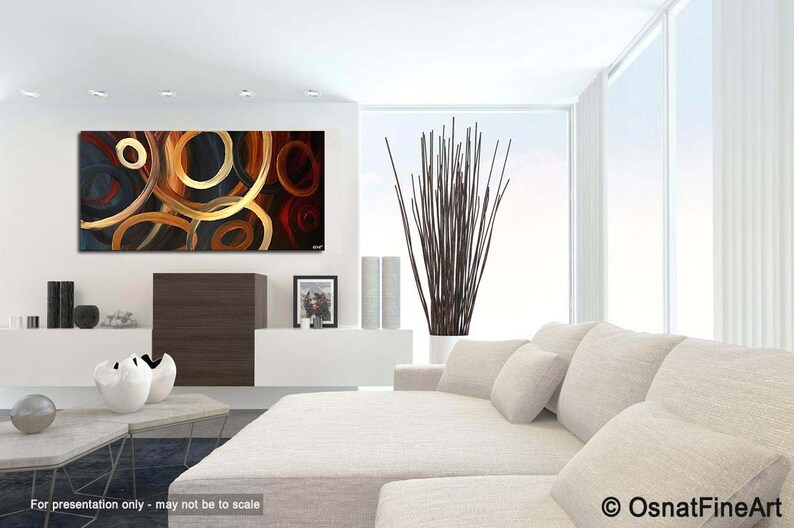 May include: Abstract painting with a modern design featuring overlapping circles in shades of gold, brown, red, and blue. The painting is displayed in a contemporary living room setting.