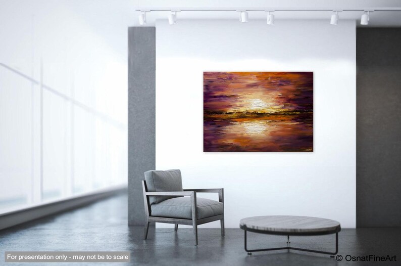 May include: Abstract painting of a sunset over a lake with purple, orange, and gold hues. The painting is displayed on a white wall in a modern interior setting.