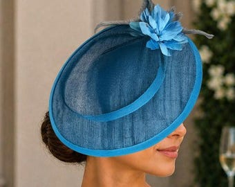 Sombrero de ocasión color turquesa de sinamay con detalles florales y de plumas.