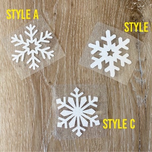 May include: Three white snowflake designs on a wood background. The snowflakes are labeled "Style A", "Style B", and "Style C".