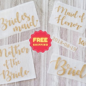 May include: Five gold glitter adhesive labels on white paper. The labels read "Bride", "Bridesmaid", "Maid of Honor", "Mother of the Bride", and "Sarah".