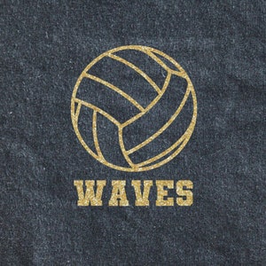 May include: A gold volleyball with the word "WAVES" underneath on a dark blue denim background.