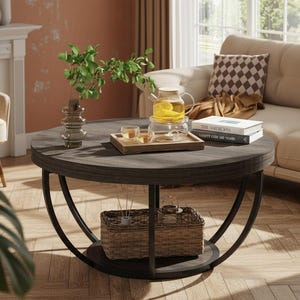 May include: A round coffee table with a dark wood grain top and a black metal frame featuring curved legs. The table includes a lower shelf holding a woven wicker basket, a glass vase with green leaves, a wooden tray with tea, and two books.