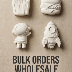 May include: Four white unpainted ceramic figures shaped like french fries, a hamburger, an astronaut, and a rocket ship. Below the figures, the text reads BULK ORDERS WHOLESALE and Multiple themes available in dark gray capital and lowercase letters.