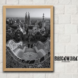 May include: Monochrome framed print of a cityscape with architectural details. The image shows buildings and a mosaic-tiled staircase. The print is mounted on a white brick wall. The text "BRICKWORK STUDIO ART" is visible.