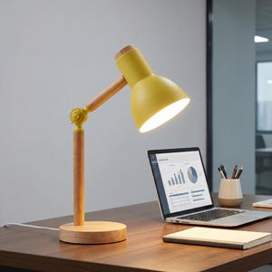 May include: A yellow desk lamp with a wooden base and arm. The lamp has a bright light and is positioned over a laptop displaying a business chart. The lamp's height is approximately 30 cm.