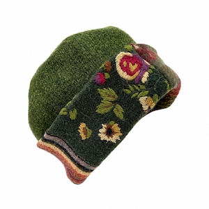 May include: A dark green wool beret featuring a wide, folded brim decorated with embroidered floral patterns in shades of red, yellow, and green. The base of the brim displays a horizontal striped border in muted tones of orange, purple, and brown.