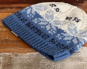May include: A blue and white knitted hat with a geometric pattern. The hat is made of wool and has a soft, comfortable feel.
