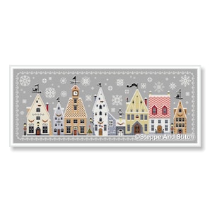 Puede incluir: Un patrón de punto de cruz que muestra una hilera de casas de estilo europeo sobre un fondo gris con copos de nieve blancos. Los edificios tienen techos variados, chimeneas y veletas. El texto Steppe And Stitch aparece abajo a la derecha.