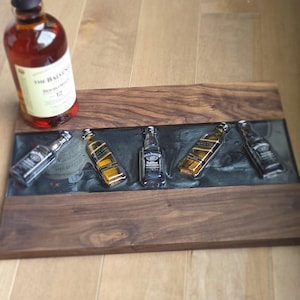 Pode incluir: Uma bandeja de madeira com uma incrusta&ccedil;&atilde;o de resina ep&oacute;xi escura, com garrafas de whisky em miniatura. Uma garrafa de The Balvenie Doublewood 12 est&aacute; &agrave; esquerda. A bandeja &eacute; feita de madeira escura.