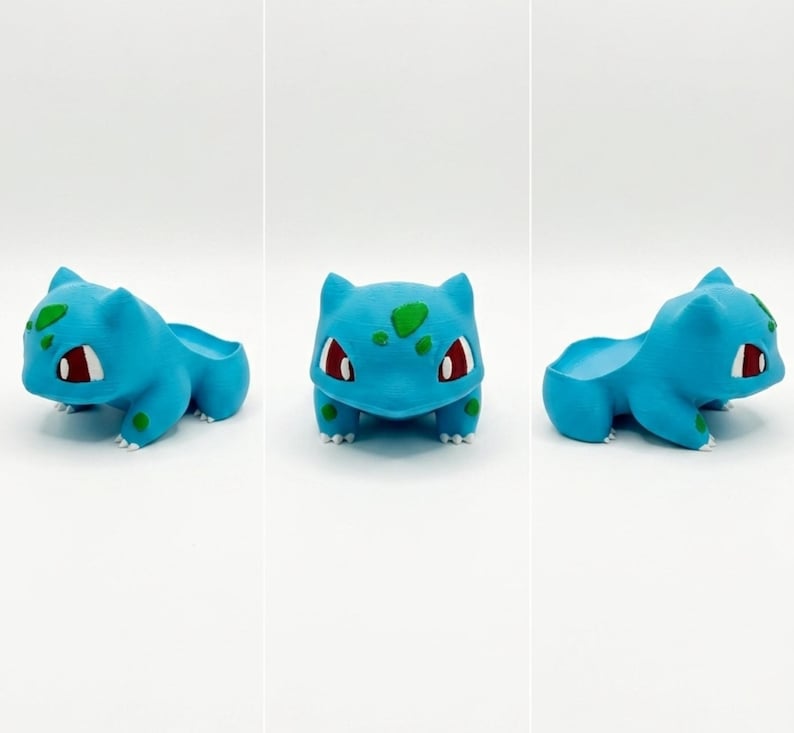 May include: A light blue Bulbasaur planter with green spots and red eyes. The planter is in the shape of the Pok&eacute;mon character, with a small opening on its back for plants. The planter is 3D printed.