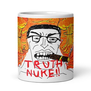 Pode incluir: Uma caneca de cerâmica branca com uma ilustração de estilo desenho à mão de uma pessoa de óculos fumando um charuto. O fundo mostra nuvens de cogumelo laranja e amarelas. O texto TRUTH NUKE!! está impresso em letras vermelhas na base.