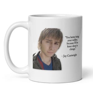 May include: White ceramic mug featuring a photo of a person and the quote: "You better bring your wellies, because I'll be knee-deep in clunge." - Jay Cartwright. The mug has a curved handle.