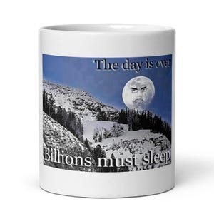 Peut inclure: Mug en céramique blanche avec une scène de montagne, une lune avec un visage et le texte "The day is over" et "Billions must sleep." Le design est imprimé sur la surface, créant un look humoristique et unique.