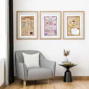 May include: Three framed prints with botanical illustrations and text. The prints are in wooden frames and feature recipes for potions and fairy cakes. The prints are displayed above a grey armchair with a white cushion.