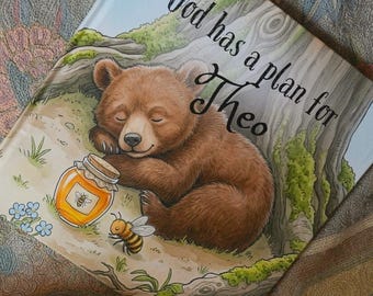 May include: A hardcover book titled God has a plan for Theo, featuring a brown bear cub sleeping near a honey jar and a bee. The illustration includes a tree trunk, green moss, small blue flowers, and red mushrooms on a light-colored forest floor.