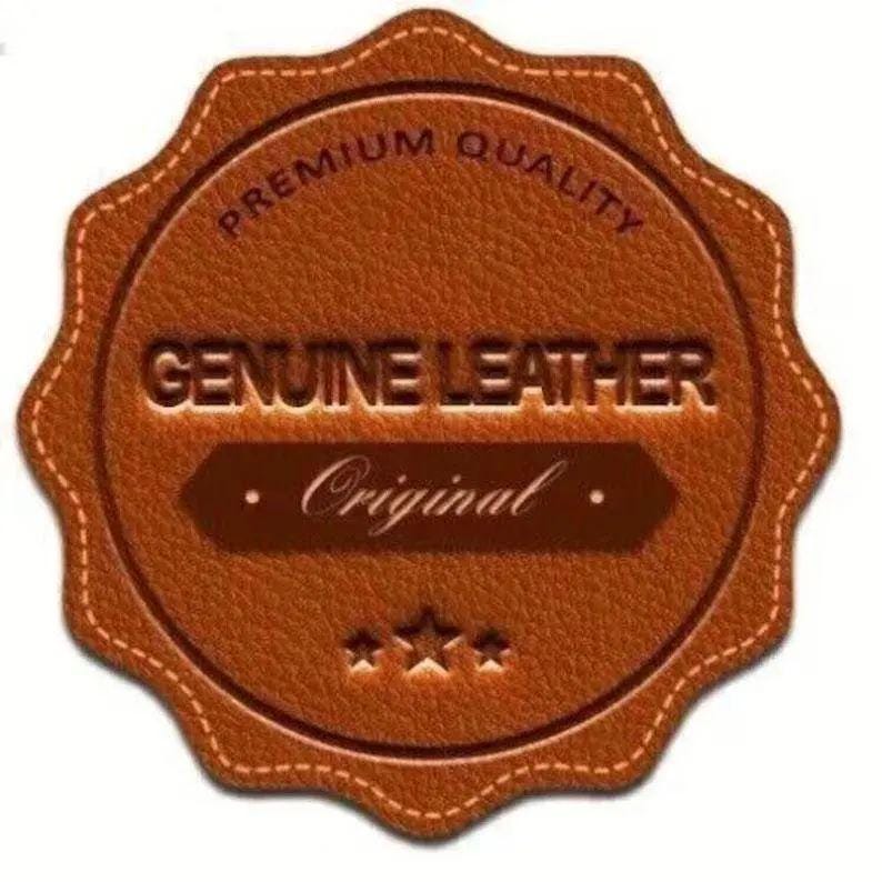 May include: A brown, scalloped-edge circular leather label featuring the embossed text PREMIUM QUALITY at the top, GENUINE LEATHER in the center, and Original on a dark brown banner, finished with three small stars at the bottom.