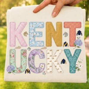 Puede incluir: Una sudadera color crema con la palabra KENTUCKY en letras grandes y estampadas. Cada letra tiene un diseño único, incluyendo texturas de cuadros vichy, flores y colores sólidos. Pequeños iconos de cabezas de caballo, sedas y flores.
