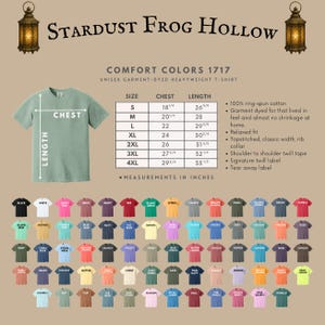 A sage green unisex garment-dyed heavyweight t-shirt with a size chart and color options. The shirt has a relaxed fit, classic width rib collar, and shoulder-to-shoulder twill tape. Measurements are in inches.