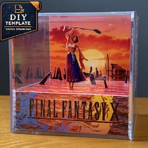 May include: A clear acrylic display box containing a 3D diorama of a character standing in water at sunset. The character wears a white top and blue skirt, holding a staff. The front of the box features the text FINAL FANTASY X in black lettering.