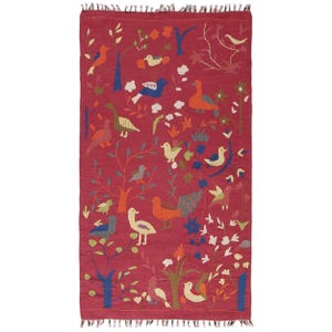 May include: A rectangular, red rug with a detailed pattern of birds, trees, and flowers. The rug features a variety of bird species in shades of blue, orange, green, and white, set against a backdrop of stylized trees and floral elements.