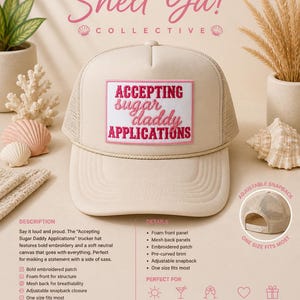 May include: A beige trucker hat with a mesh back and a pre-curved brim. The hat features a rectangular patch with the text "ACCEPTING sugar daddy APPLICATIONS" in pink and white embroidery. The hat has an adjustable snapback closure.