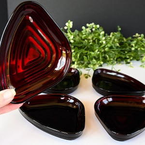 Op de afbeelding: Set van vijf rode glazen driehoekige schalen. De schalen zijn allemaal even groot en hebben dezelfde vorm, en ze hebben een licht verhoogde rand. De schalen zijn perfect om snacks, dips of sauzen te serveren.