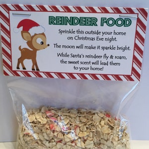 May include: A clear plastic bag filled with reindeer food, a mixture of oats and red candy pieces. The bag has a red and white striped label with the text "REINDEER FOOD" and instructions to sprinkle the food outside on Christmas Eve.