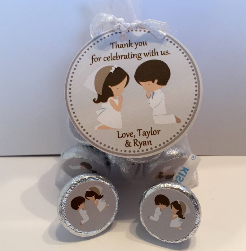 May include: A silver bag filled with chocolate kisses with a personalized tag. The tag features a cartoon illustration of a bride and groom with the text "Thank you for celebrating with us. Love, Taylor & Ryan".