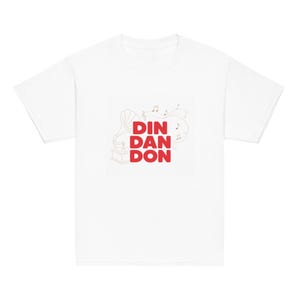 May include: A white short-sleeved t-shirt featuring a graphic print on the chest. The design includes a line-art illustration of a vintage gramophone, musical notes, and the bold red text DIN DAN DON centered in a stacked layout.