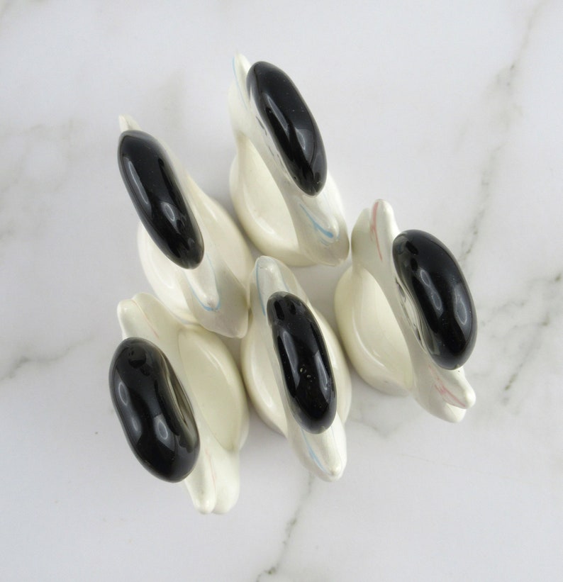 Puede incluir: Conjunto de cinco anillos de servilleta de cer&aacute;mica blanca en forma de cisne con detalles negros. Cada anillo presenta un cisne con cabeza y cuello negros y cuerpo blanco. Los anillos son perfectos para a&ntilde;adir un toque de elegancia a cualquier mesa.