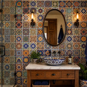 May include: A bathroom vanity area featuring a white marble countertop, a round vessel sink with blue and orange floral patterns, and a wooden cabinet. The wall is covered in square ceramic tiles with intricate, colorful geometric designs.