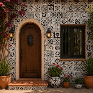 May include: A house exterior featuring a wall covered in black and white patterned square tiles, a dark wood arched door with a small iron-grated window, a black-framed window, and the number 127 displayed on a tile plaque near the entrance.