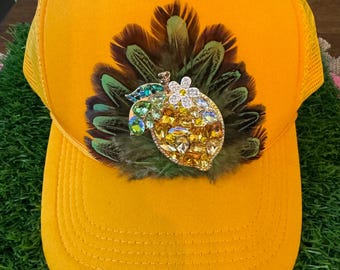 Gorra de camionero con plumas y un gran limón.