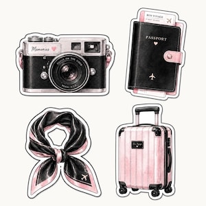以下が含まれることがあります： 旅行をテーマにしたステッカーのコレクション。 「Memories」の文字が入った黒とシルバーのカメラ、ピンクのアクセントが付いた黒のパスポート、黒とピンクのスカーフ、黒のアクセントが付いたピンクのスーツケースが含まれています。